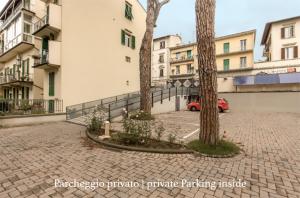 a parking lot with two trees and buildings at Gourmet B&B Villa Landucci in Florence