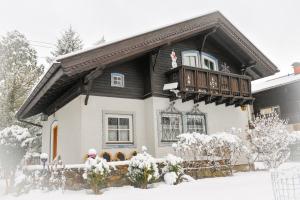 a house with a balcony in the snow at Rosis Cottage in Lienz