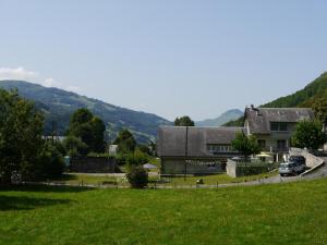 una casa con un campo verde delante de una casa en Le Hameau de Campan, en Sainte-Marie-de-Campan