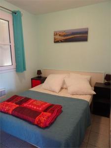 Un dormitorio con una cama con una manta roja. en T2 Vue mer Clim et WiFi, en Cerbère