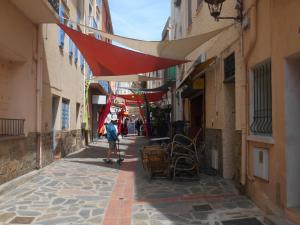 una persona caminando por una calle con un toldo rojo en T2 Vue mer Clim et WiFi, en Cerbère