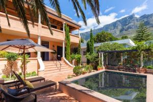 una casa con piscina frente a una casa en Kensington Views, en Ciudad del Cabo