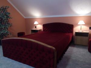 a bedroom with a large bed with a red bedspread at Üttörő út 177 B in Balatonfenyves