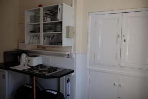 a kitchen with a stove and a white cabinet at Newbrough Bunkhouse in Hexham