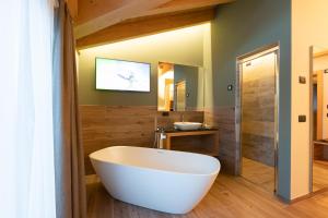 a bathroom with a large white tub and a sink at Hotel Centro's in Livigno