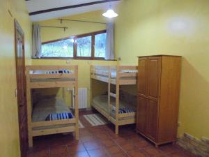 a room with three bunk beds and a window at Albergue Areitz Soroa in Arce