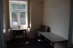 a room with a desk and a table and a window at Newbrough Bunkhouse in Hexham