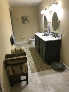 a bathroom with a sink and a toilet and a chair at Elegant Jewel in Lithonia