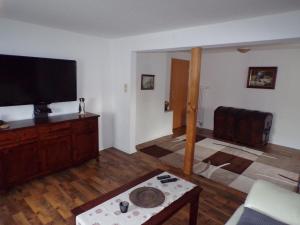 a living room with a flat screen tv and a table at Ferienwohnung am Greifswalder Bodden in Wieck
