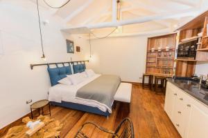 a bedroom with a large bed and a kitchen at X.O Art House in Cusco