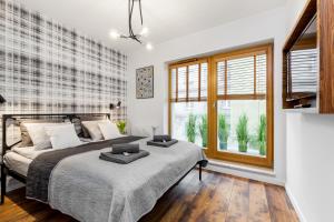 - une chambre avec un grand lit et une fenêtre dans l'établissement Apartamenty Black&White - Apartament Loft Style, à Gdynia