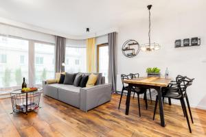 salon z kanapą i stołem w obiekcie Apartamenty Black&White - Apartament Loft Style w mieście Gdynia