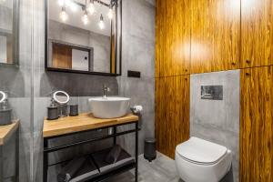 a bathroom with a sink and a toilet at Apartamenty Black&White - Apartament Loft Style in Gdynia +19 photos