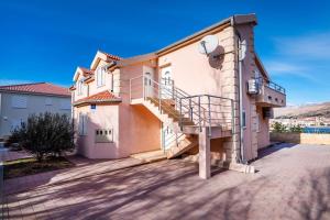 una casa con una escalera en el lateral de ella en Apartments Matej, en Pag