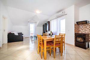 a dining room with a table and chairs and a fireplace at Apartments Matej in Pag
