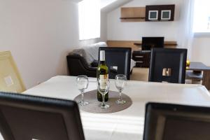 a bottle of wine and two glasses on a table at Apartments Matej in Pag