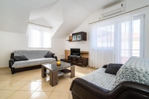a living room with a couch and a table at Apartments Matej in Pag +15 photos