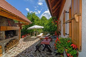 un patio al aire libre con mesa y sombrilla en Sobol in Kočičin (Haus für 6-9 Personen), en Kuželj