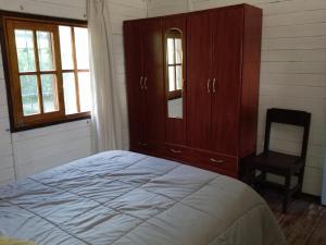 1 dormitorio con 1 cama, vestidor y silla en Piccolo Paradiso, en La Pedrera