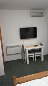 a white room with a table and a tv on a wall at Motel Jelčić in Čapljina