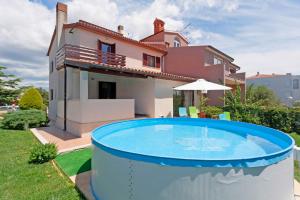 una casa con piscina di fronte a una casa di Nada in Vinkuran (Haus für 8 Personen) a Pola (Pula)