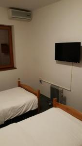 a room with two beds and a flat screen tv at Motel Jelčić in Čapljina