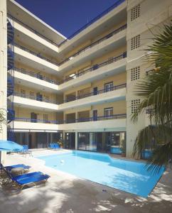 a large building with a swimming pool in front of it at Jason Hotel Apartments in Rethymno