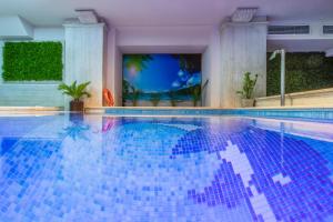 una piscina con azulejos azules en el agua en Egnatia Palace Hotel & Spa, en Tesalónica