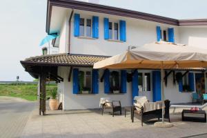 a building with two umbrellas and chairs in front of it at Villa Roma Holidays in Jesolo