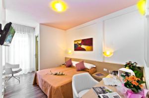 una camera d'albergo con letto e soggiorno di Hotel Victoria a Bibione