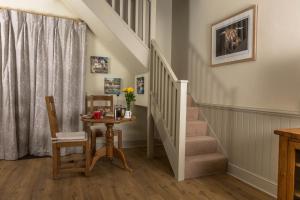 a stairway with a table and chairs and a staircase at The Dovecote, Stoke Farthing Courtyard in Broad Chalke
