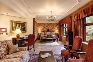 ein Wohnzimmer mit einem Sofa und einem Tisch in der Unterkunft Pennyhill Park Hotel and Spa in Bagshot