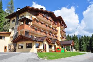 a large apartment building with balconies and a playground at Residence Panorama in Falcade