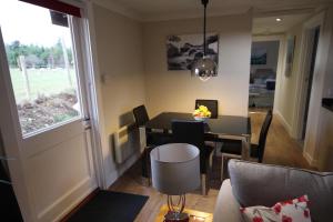 a dining room and living room with a table and chairs at Easter Arr Courtyard Apartment in Nairn