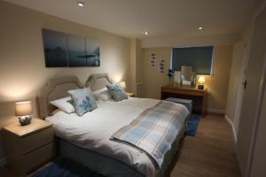 a bedroom with a large white bed with blue pillows at Easter Arr Courtyard Apartment in Nairn