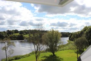 a view of a river from the balcony of a house at Lakeside Studio 2 Loft Apartment in Enniskillen