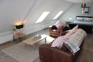 ein Wohnzimmer mit einem Sofa, einem Bett und einem Tisch in der Unterkunft Lakeside Studio 2 Loft Apartment in Enniskillen