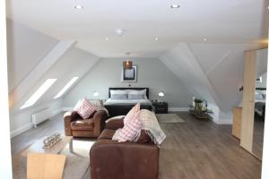 Schlafzimmer im Dachgeschoss mit einem Bett und einem Sofa in der Unterkunft Lakeside Studio 2 Loft Apartment in Enniskillen