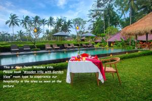 a table with a red table cloth next to a pool at Alam Dania Cottage in Ubud