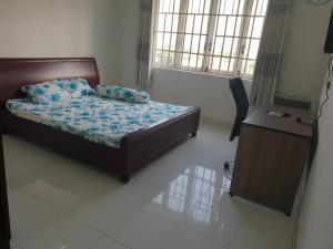 Schlafzimmer mit einem Bett, einem Schreibtisch und Fenstern in der Unterkunft Big room in Ho-Chi-Minh-Stadt