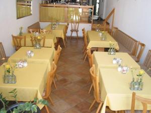 a restaurant with tables and chairs with flowers on them at Hotel Gästehaus Theresia Garni in Mühlheim an der Donau