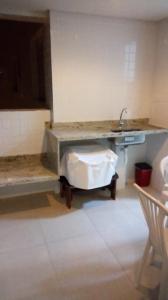 a bathroom with a sink and a counter with a sink at Edifício Copacabana frente para mar in Mongaguá