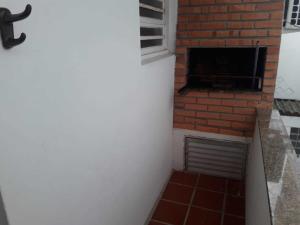 a brick fireplace in the corner of a room at Capão 2 Dormitorios in Capão da Canoa