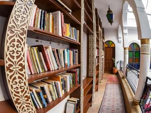 a library with wooden shelves filled with books at Funky Fes in Fez
