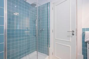a bathroom with a shower with blue tiles at Liiiving In Porto | Downtown Luxury Apartments in Porto +135 photos