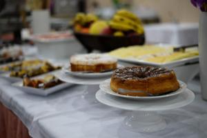 a table filled with cakes and pastries on top of plates at Caravelle Palace Hotel in Curitiba