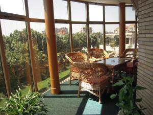 a porch with a table and chairs and windows at Hotel Dambovita in Târgovişte