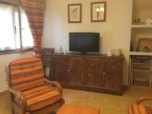 a living room with a television and a chair at Casa Sanabresa in Galende