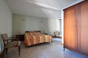 1 dormitorio con cama, silla y vestidor en GITE DU FLORIMONT CENTRE ALSACE route des vins, en Ingersheim