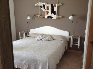 a bedroom with a bed with a cow hanging on the wall at Casa Pramas in Orosei